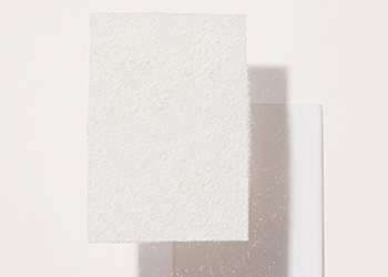 Obrúsky pohlcujúce mastnotu a Mary Kay® Transparentný sypký púder naaranžované na neutrálnom pozadí a vytvárajúce tiene.